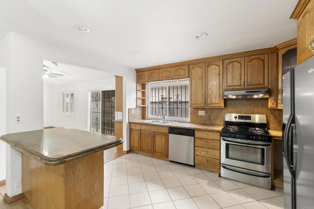 1850 Paradise Hills Road San Diego, CA 92114 - Photo 14 of 39 a kitchen with granite countertop a sink appliances and cabinets