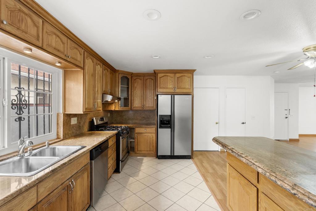 1850 Paradise Hills Road San Diego, CA 92114 - Photo 15 of 39 a kitchen with stainless steel appliances granite countertop a sink stove and refrigerator