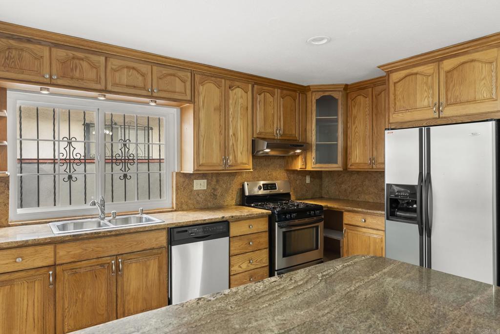 1850 Paradise Hills Road San Diego, CA 92114 - Photo 16 of 39 a kitchen with stainless steel appliances granite countertop a stove a sink dishwasher and a refrigerator