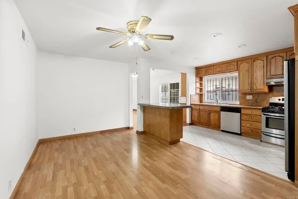 a view of a room with wooden floor and a ceiling fan