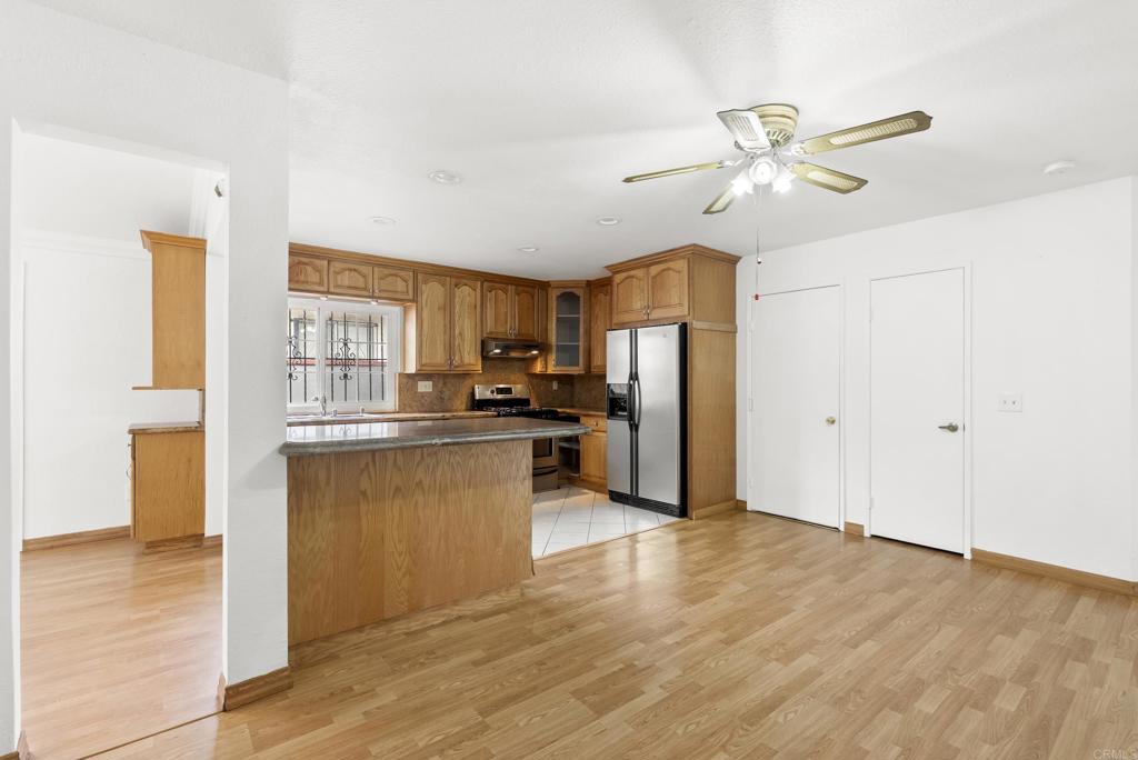 1850 Paradise Hills Road San Diego, CA 92114 - Photo 18 of 39 a kitchen with stainless steel appliances kitchen island granite countertop a refrigerator and a stove top oven