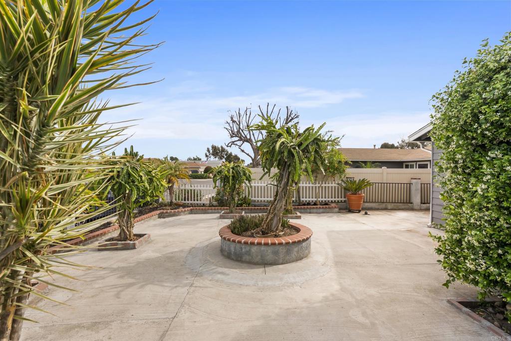 1850 Paradise Hills Road San Diego, CA 92114 - Photo 7 of 39 a view of a backyard with table and chairs potted plants and palm tree