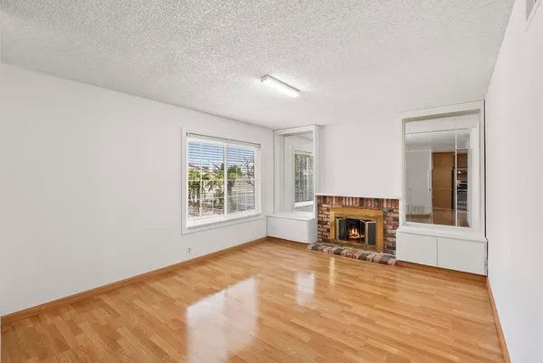 a view of empty room with wooden floor and fireplace