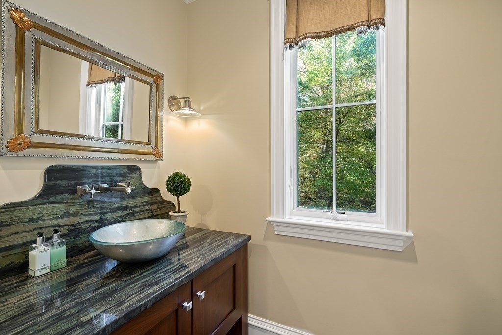 22 McCall Road Winchester, MA 01890 - Photo 17 of 40 a bathroom with a granite countertop sink and a mirror