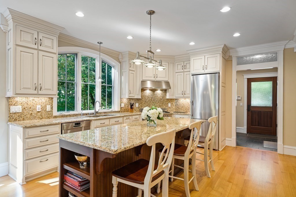 22 McCall Road Winchester, MA 01890 - Photo 9 of 40 a kitchen with a table chairs refrigerator and cabinets