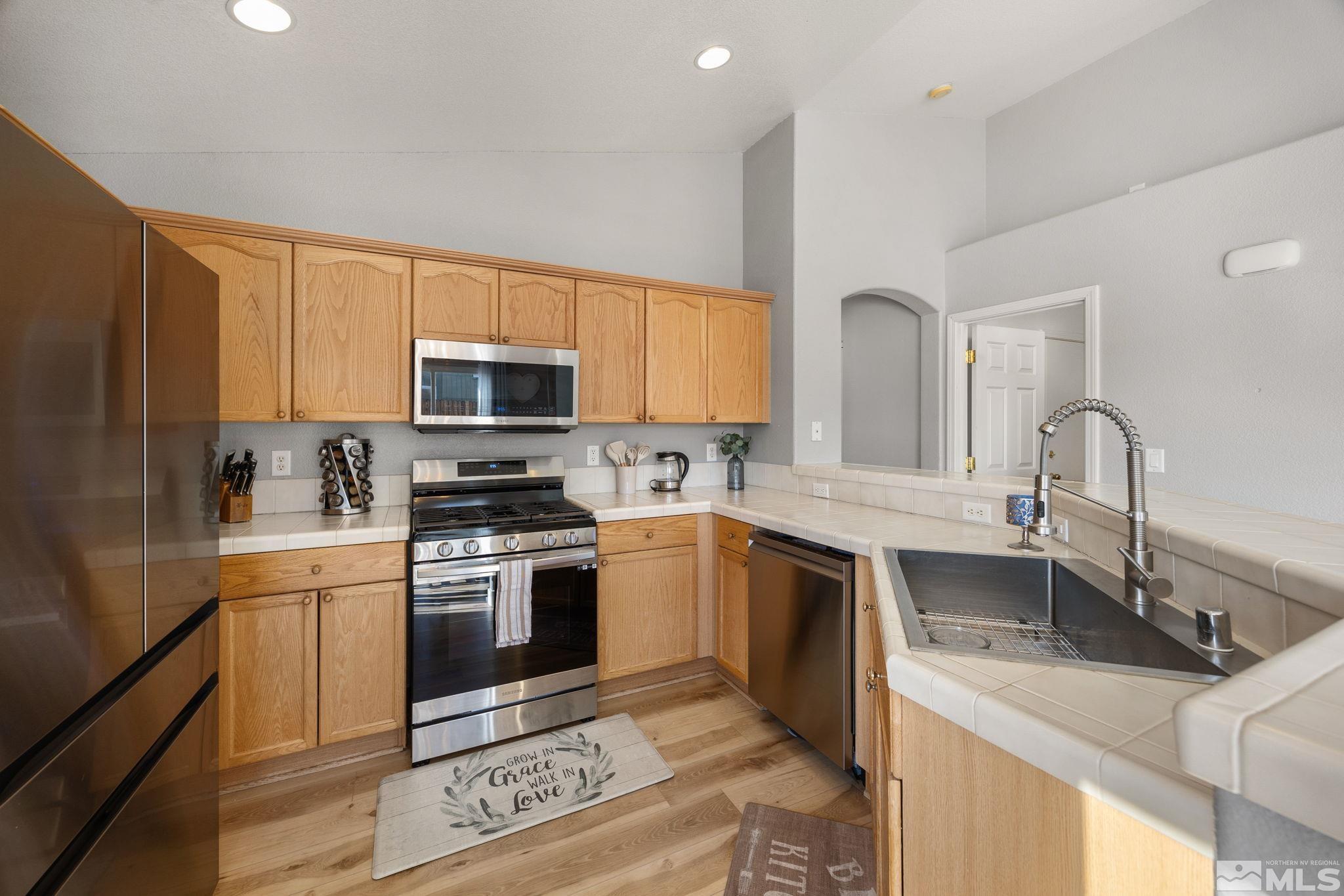 224 Bartmess Boulevard Sparks, NV 89436 - Photo 5 of 20 a kitchen with stainless steel appliances granite countertop a sink stove and microwave