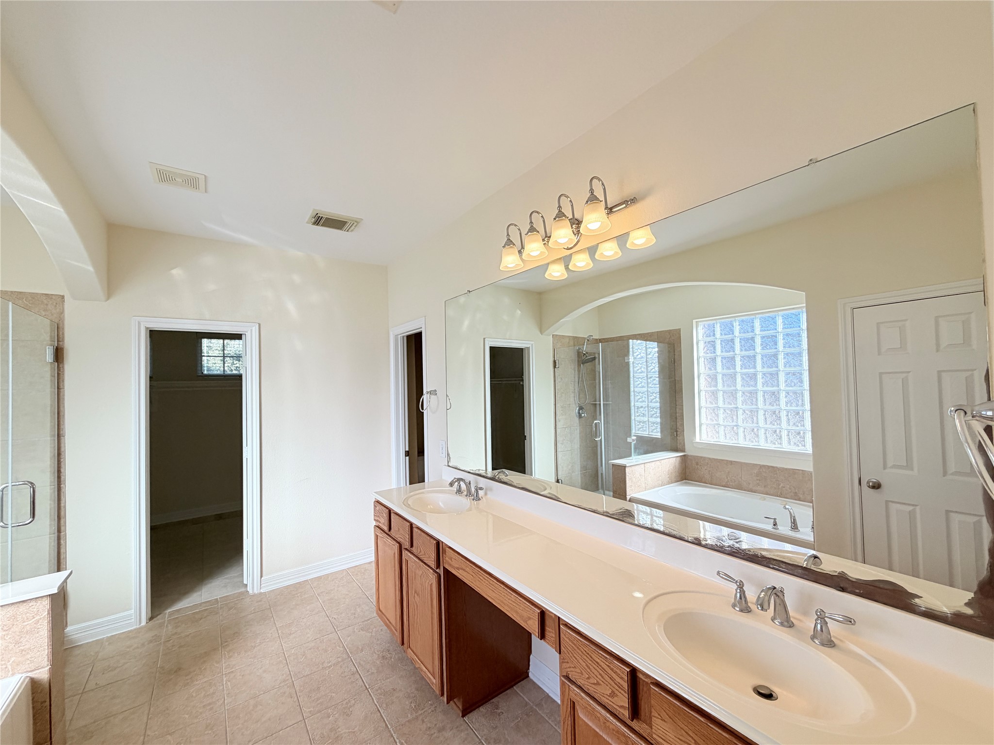 28015 Silverstream Court Fulshear, TX 77441 - Photo 15 of 33 a bathroom with a granite countertop sink a large mirror and a shower