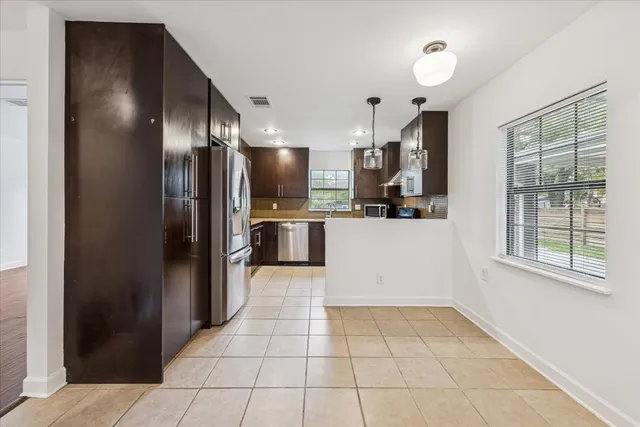 a kitchen with granite countertop a stove a sink and a refrigerator