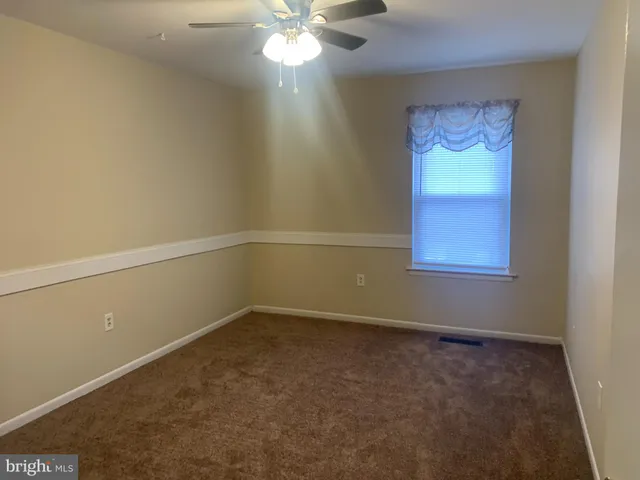 an empty room with a window and a fan