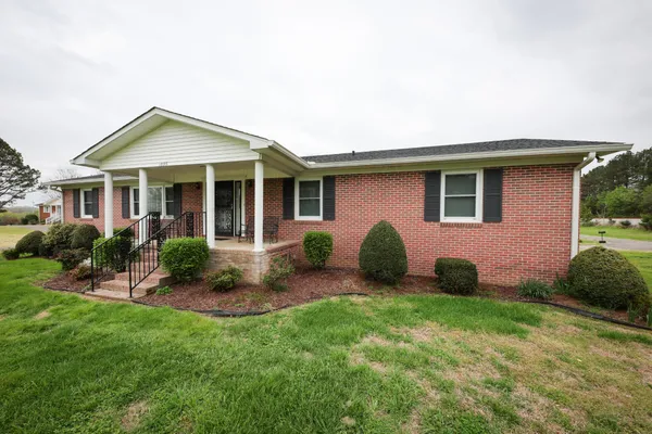 a view of a house with backyard and porch