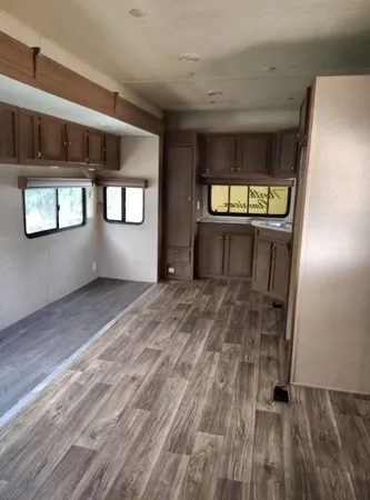 a view of an empty room with window and stairs