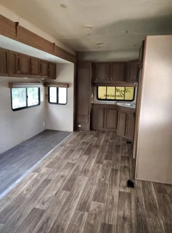 a view of an empty room with window and stairs