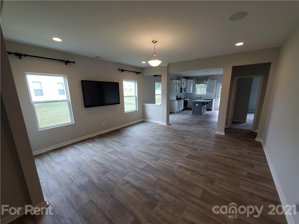 8633 River Ridge Drive Charlotte, NC 28213 - Photo 5 of 23 an empty room with wooden floor and a kitchen