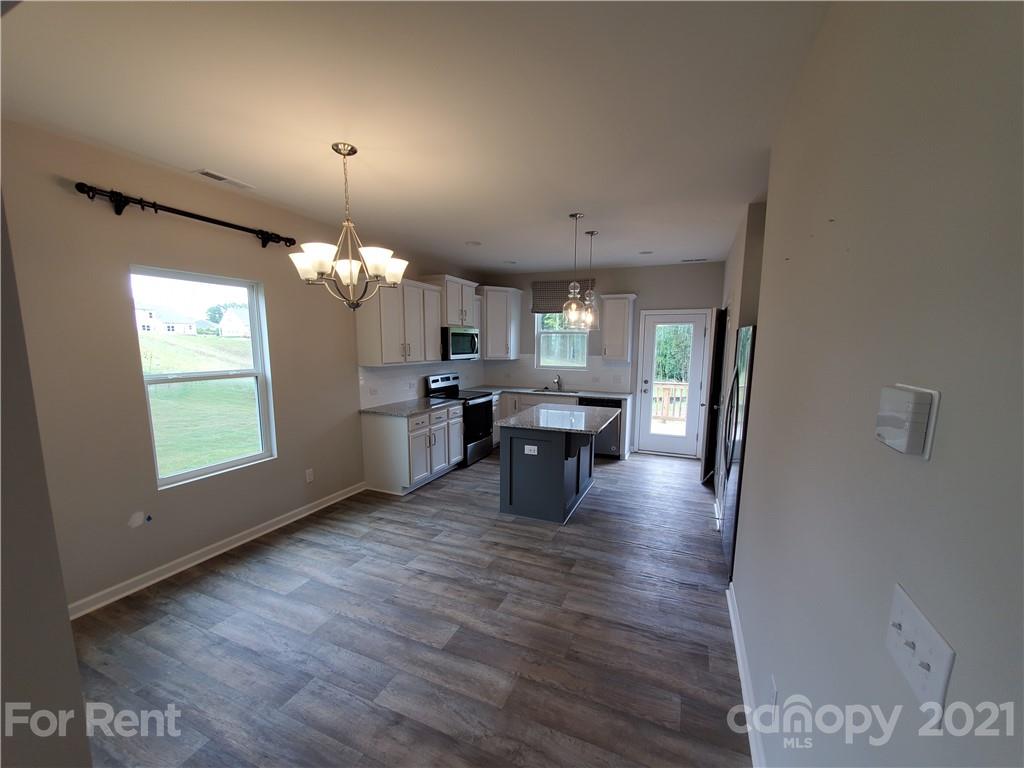 8633 River Ridge Drive Charlotte, NC 28213 - Photo 6 of 23 a view of a room with wooden floor chandelier and windows