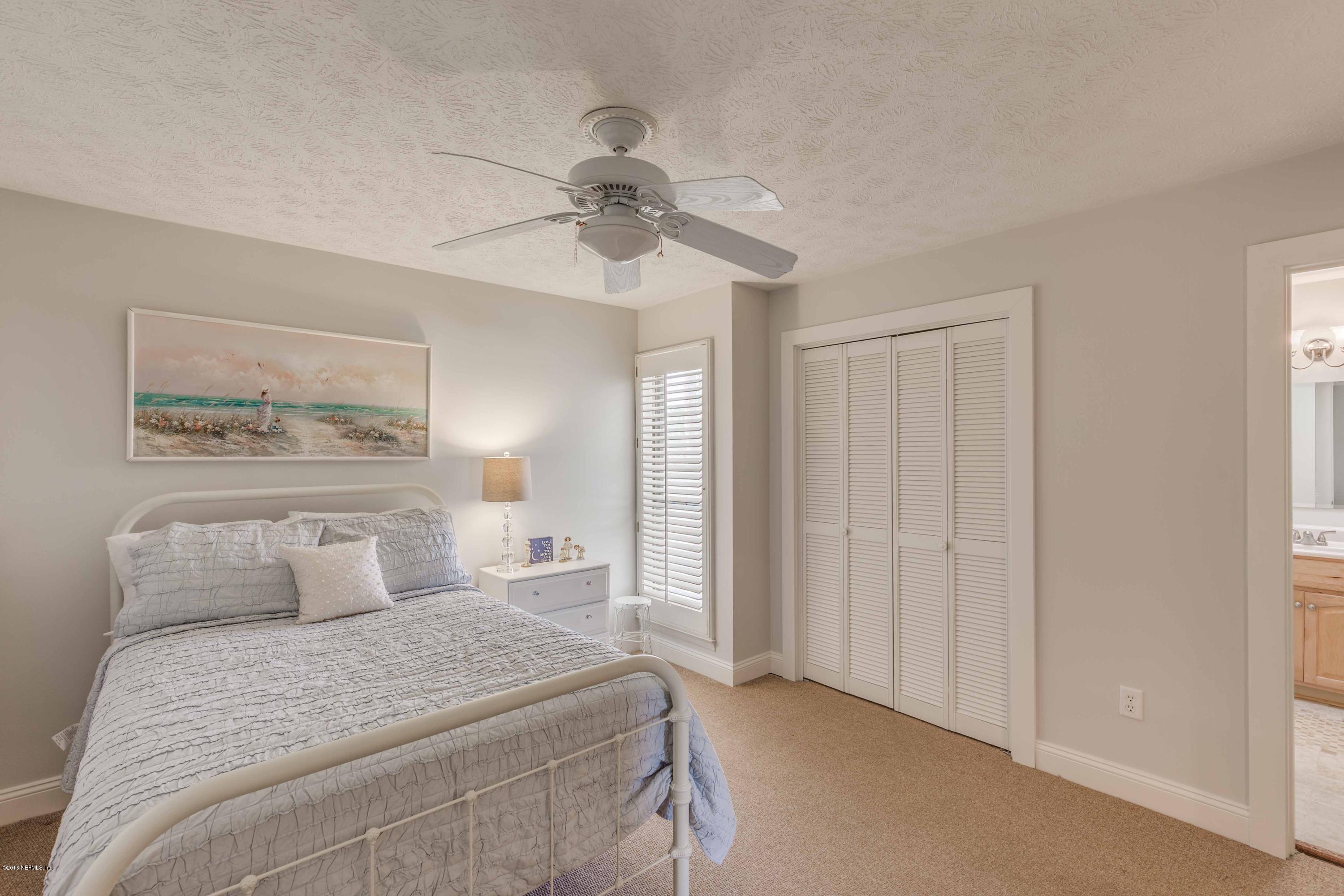 1755 Seminole Road Atlantic Beach, FL 32233 - Photo 16 of 28 a bedroom with a large bed and a chandelier
