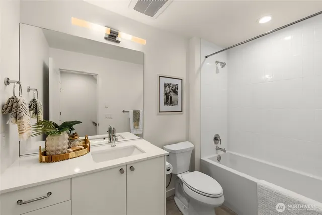 a bathroom with a sink a toilet a shower and a mirror