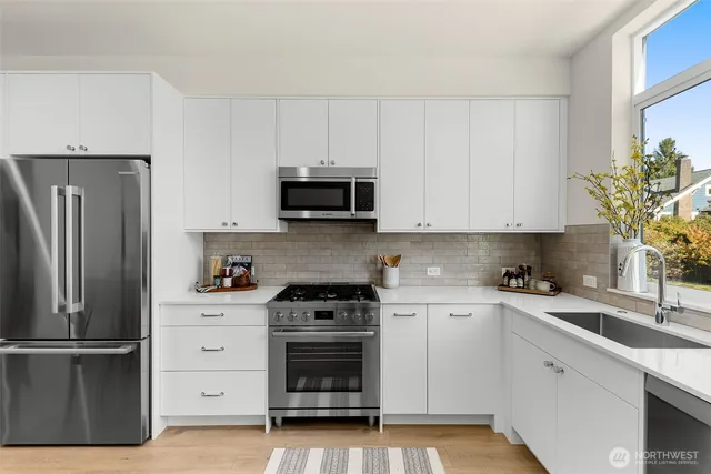 a kitchen with cabinets stainless steel appliances and a window