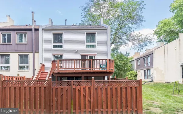 a view of a house with wooden deck and furniture