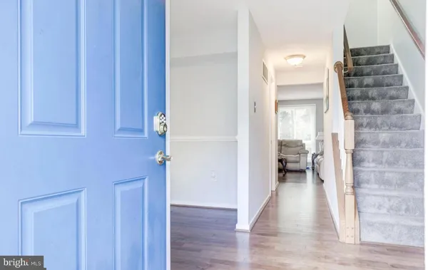 a view of a hallway with wooden floor and staircase