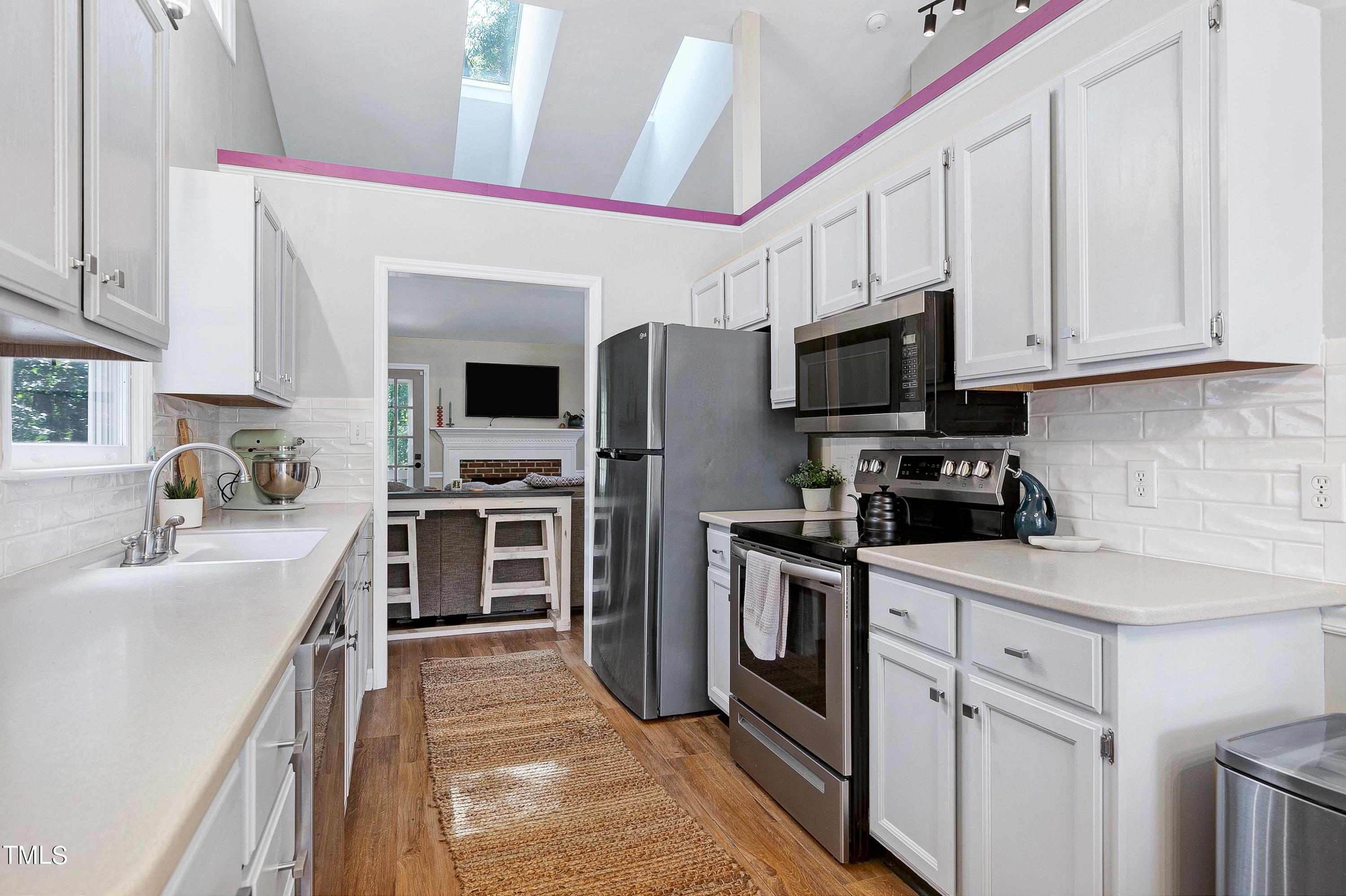 4700 Jacqueline Lane Raleigh, NC 27616 - Photo 12 of 40 a kitchen with stainless steel appliances a stove sink microwave and cabinets