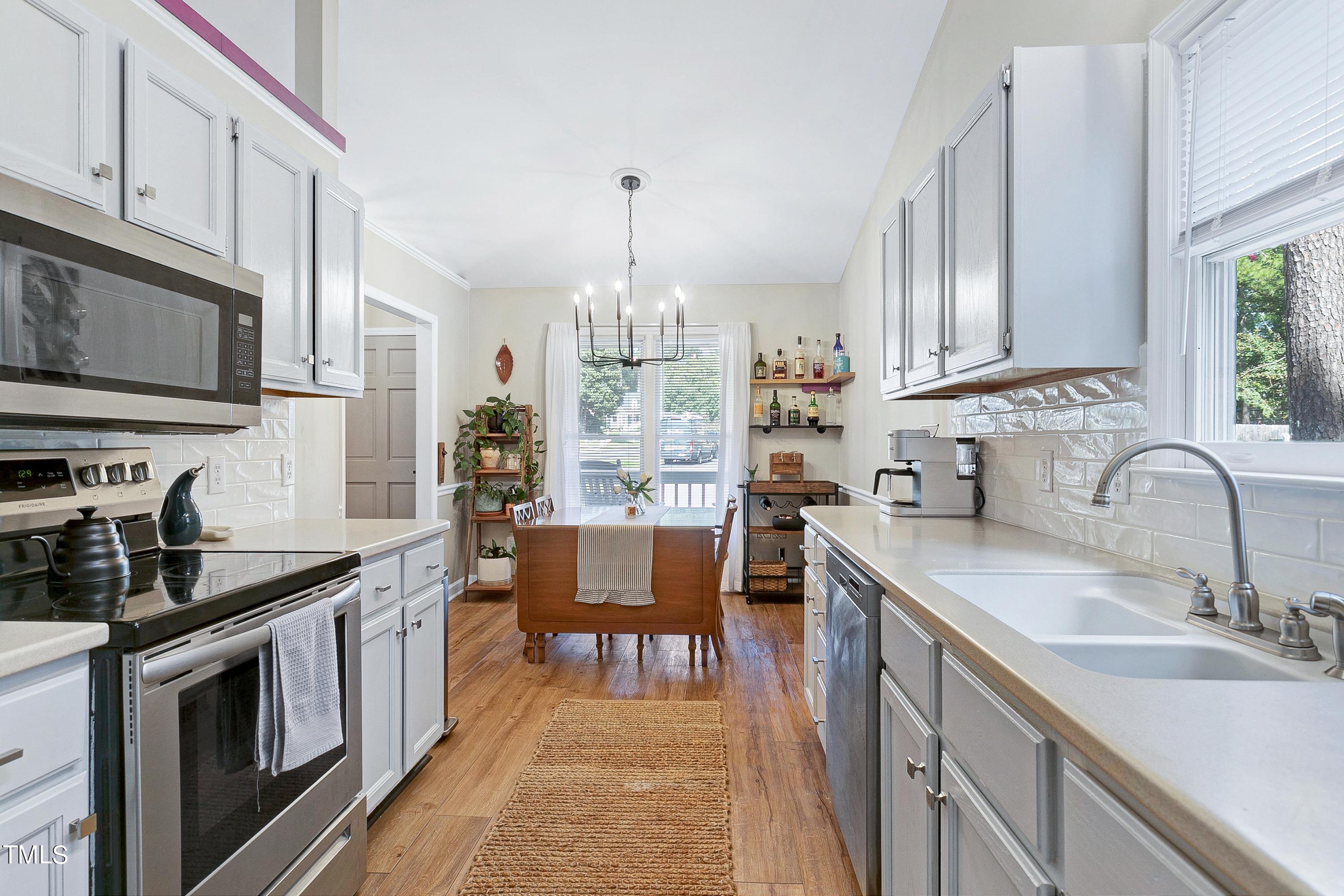 4700 Jacqueline Lane Raleigh, NC 27616 - Photo 13 of 40 a kitchen with granite countertop a sink stove and cabinets