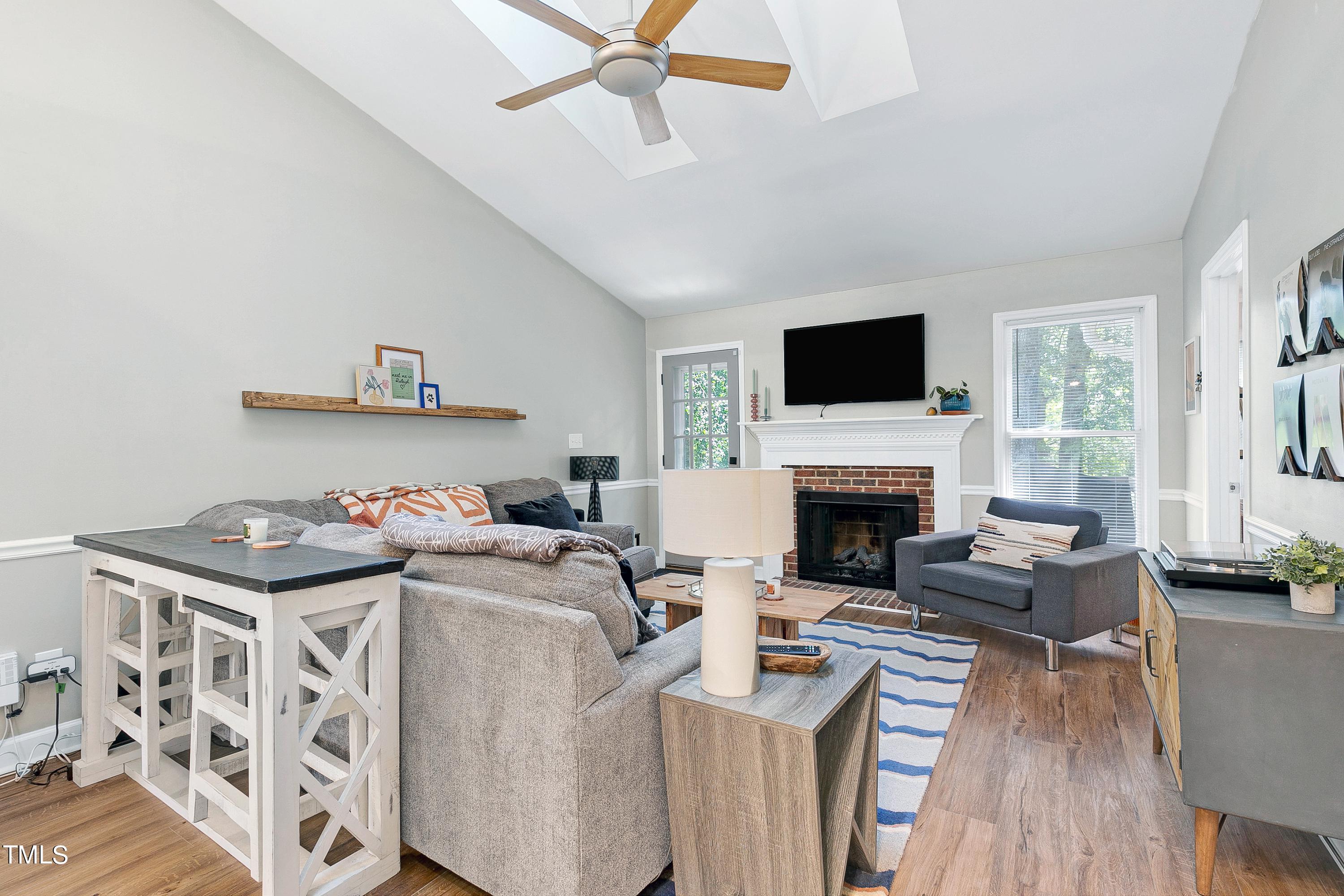 4700 Jacqueline Lane Raleigh, NC 27616 - Photo 16 of 40 a living room with furniture a fireplace and a flat screen tv