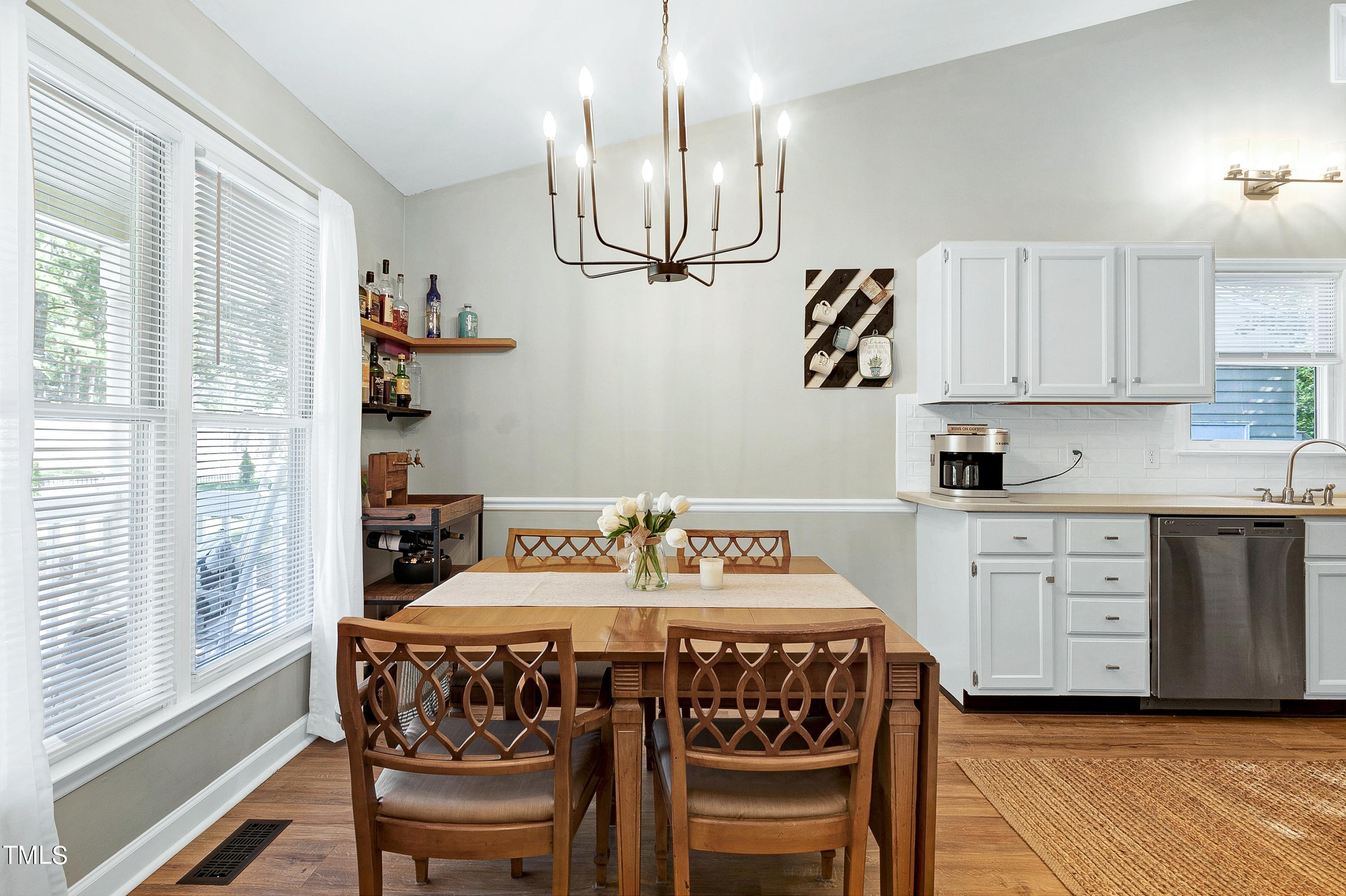 4700 Jacqueline Lane Raleigh, NC 27616 - Photo 7 of 40 a kitchen with stainless steel appliances a table chairs and chandelier