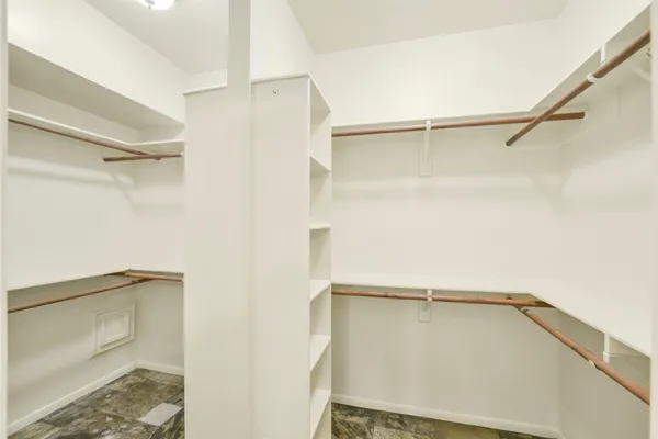 a view of walk in closet with empty racks