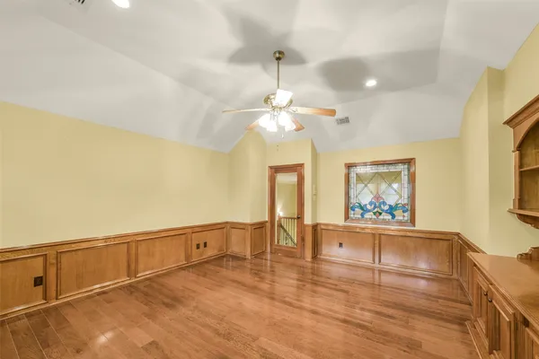 a view of an empty room with window and wooden floor