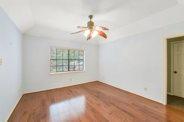 a view of a room with wooden floor closet and a chandelier fan