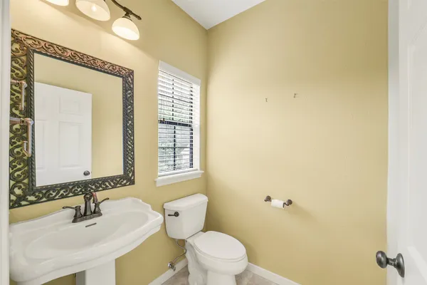 a bathroom with a sink a toilet and a mirror