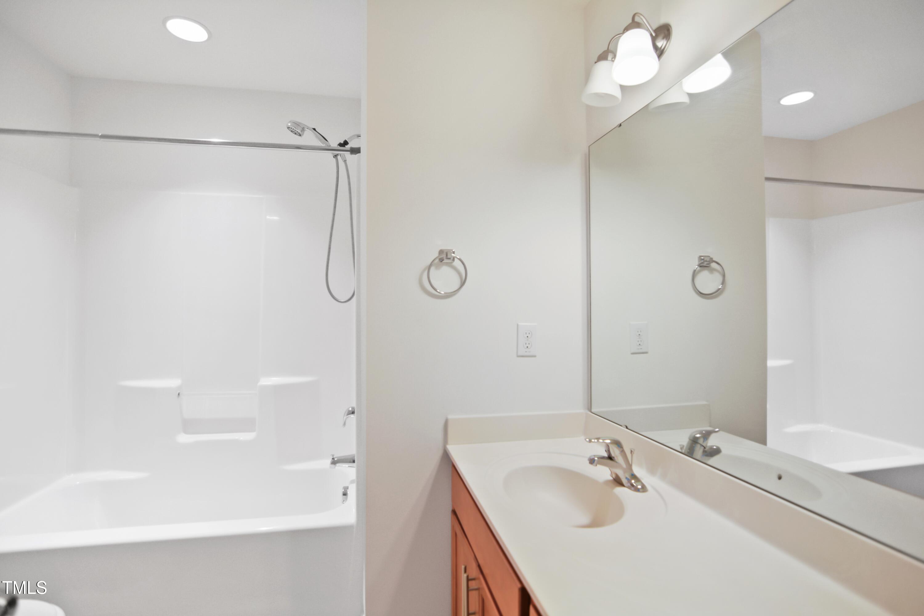 2901 Benevolence Drive Raleigh, NC 27610 - Photo 16 of 18 a bathroom with a tub sink shower and mirror