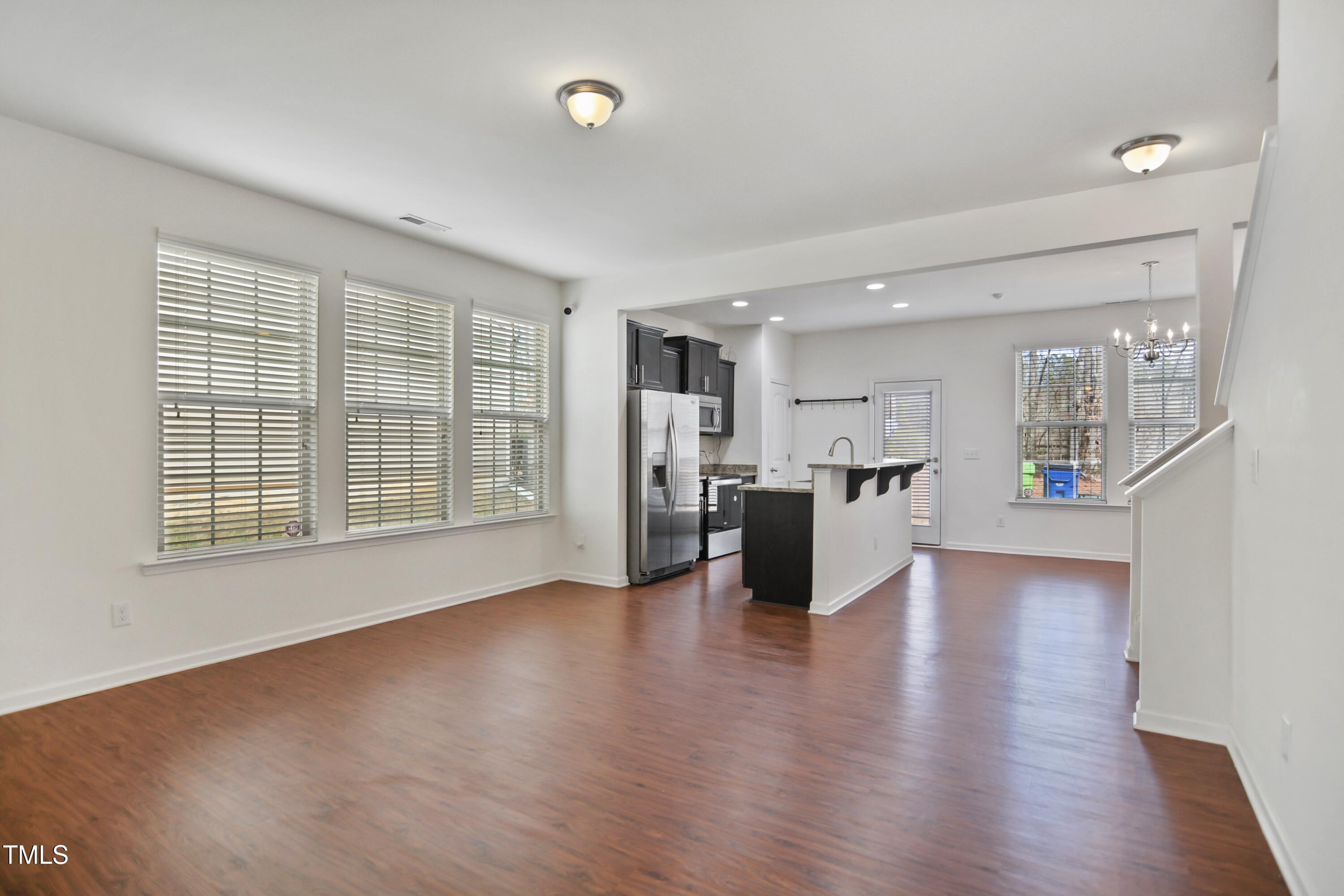 2901 Benevolence Drive Raleigh, NC 27610 - Photo 3 of 18 a view of an empty room with wooden floor and a kitchen