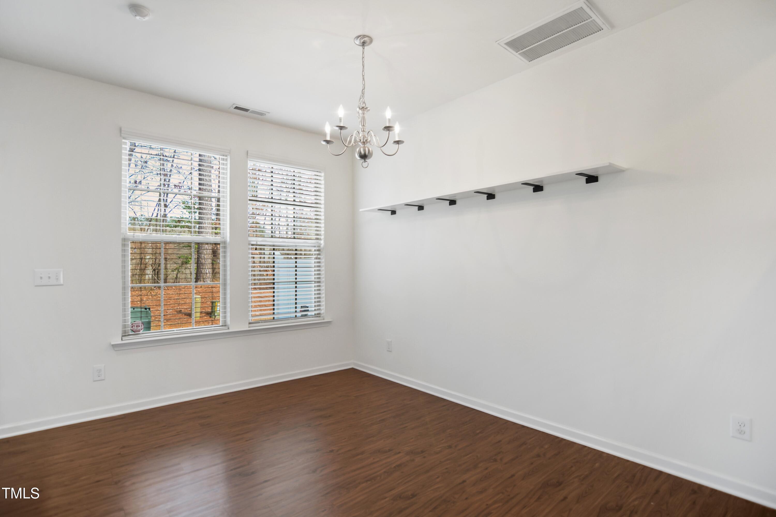 2901 Benevolence Drive Raleigh, NC 27610 - Photo 5 of 18 an empty room with wooden floor and windows