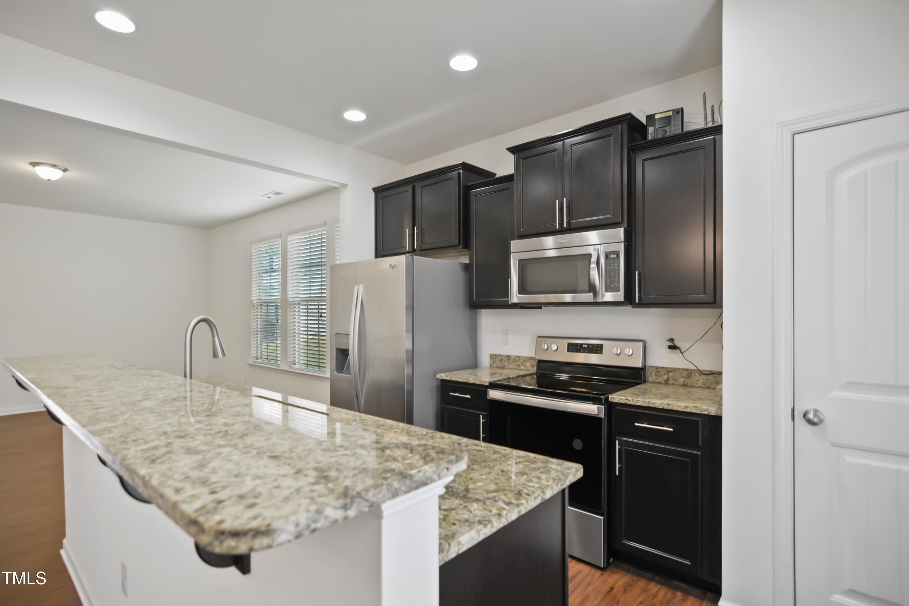 2901 Benevolence Drive Raleigh, NC 27610 - Photo 8 of 18 a kitchen with stainless steel appliances granite countertop a sink stove and refrigerator