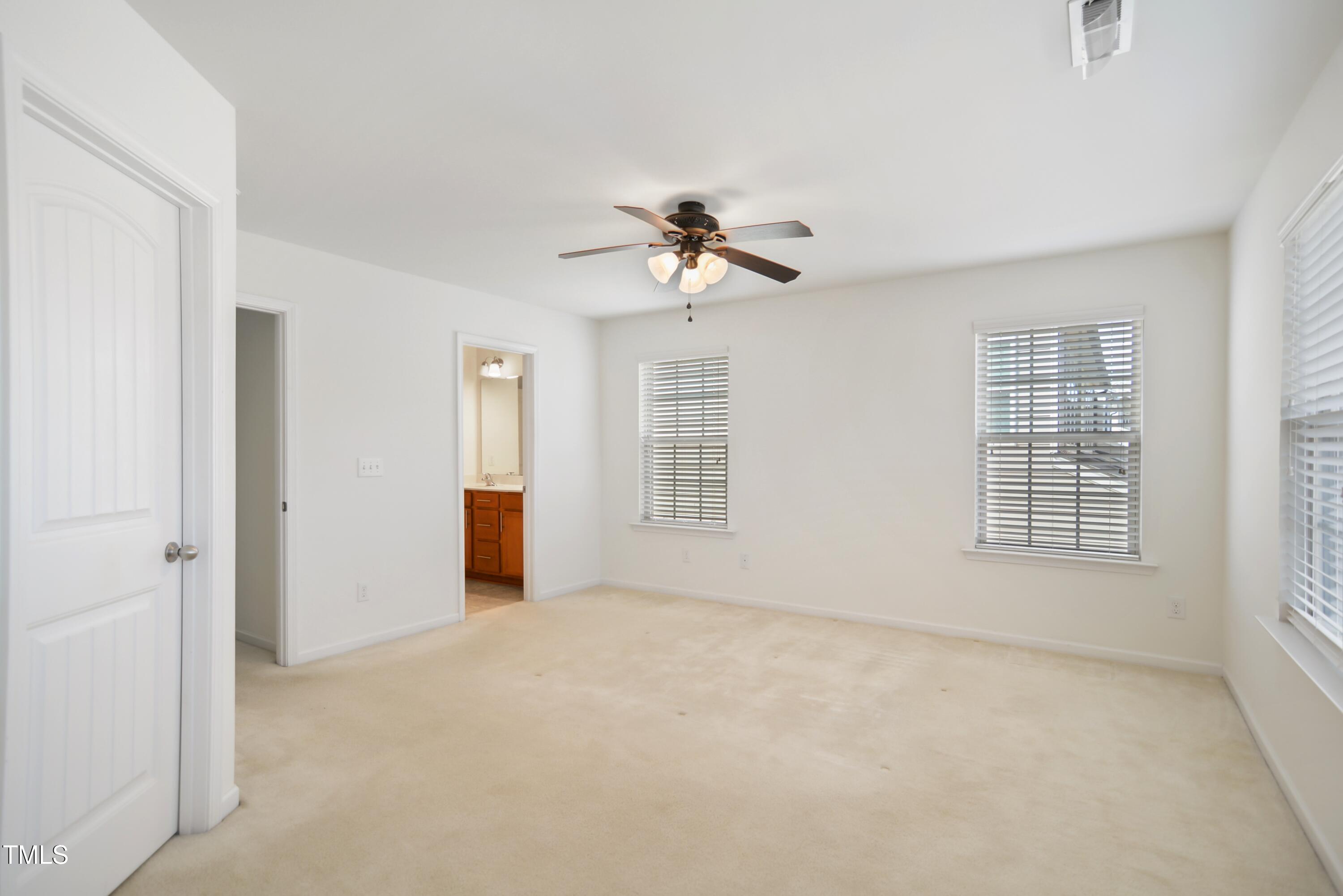 2901 Benevolence Drive Raleigh, NC 27610 - Photo 10 of 18 an empty room with chandelier fan and windows