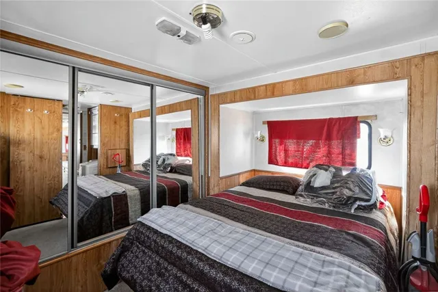 a bedroom with a bed and a large mirror with a bathtub