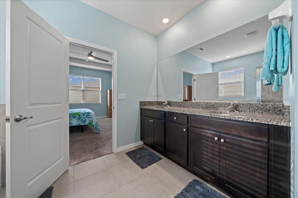6138 Southwest 89th Ln Road Ocala, FL 34476 - Photo 40 of 74 a spacious bathroom with a granite countertop sink and a mirror