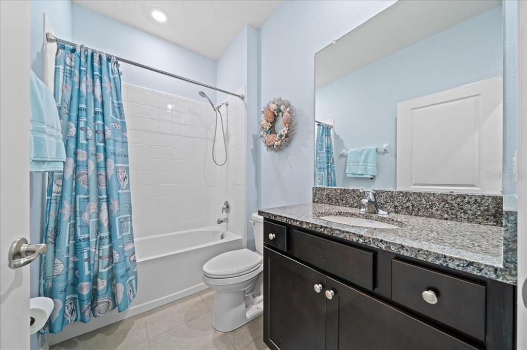 6138 Southwest 89th Ln Road Ocala, FL 34476 - Photo 48 of 74 a bathroom with a granite countertop sink a toilet and shower