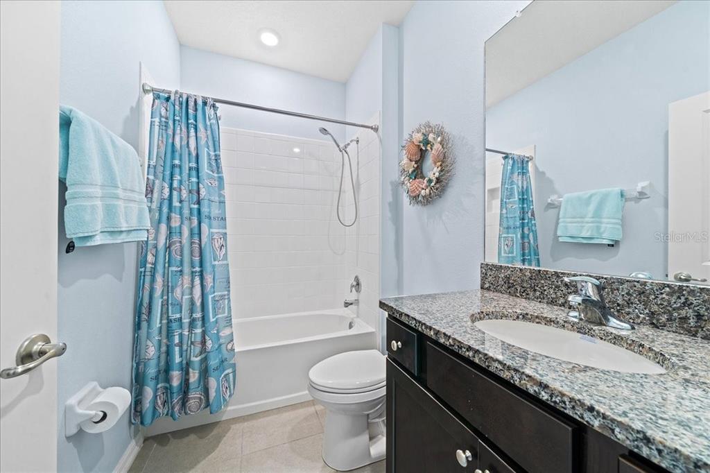 6138 Southwest 89th Ln Road Ocala, FL 34476 - Photo 49 of 74 a bathroom with a granite countertop sink a toilet and shower