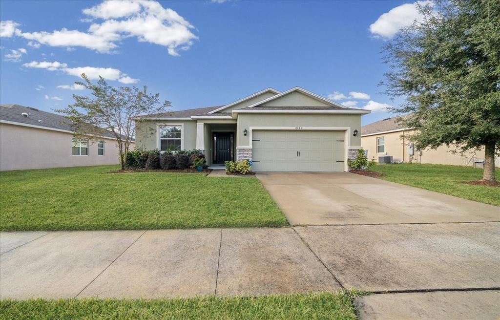 6138 Southwest 89th Ln Road Ocala, FL 34476 - Photo 55 of 74 a front view of a house with a garden and trees