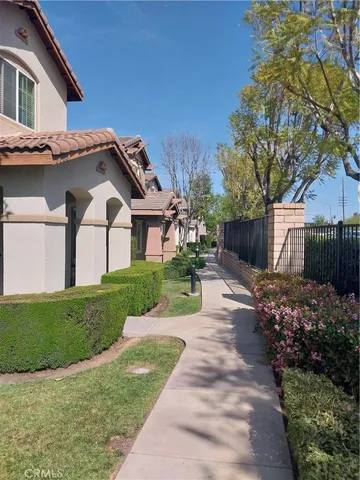 a front view of a house with a garden and trees
