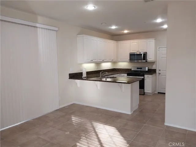 a kitchen with kitchen island a stove top oven and cabinets