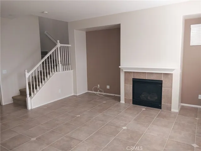 a view of an empty room with a fireplace and a window