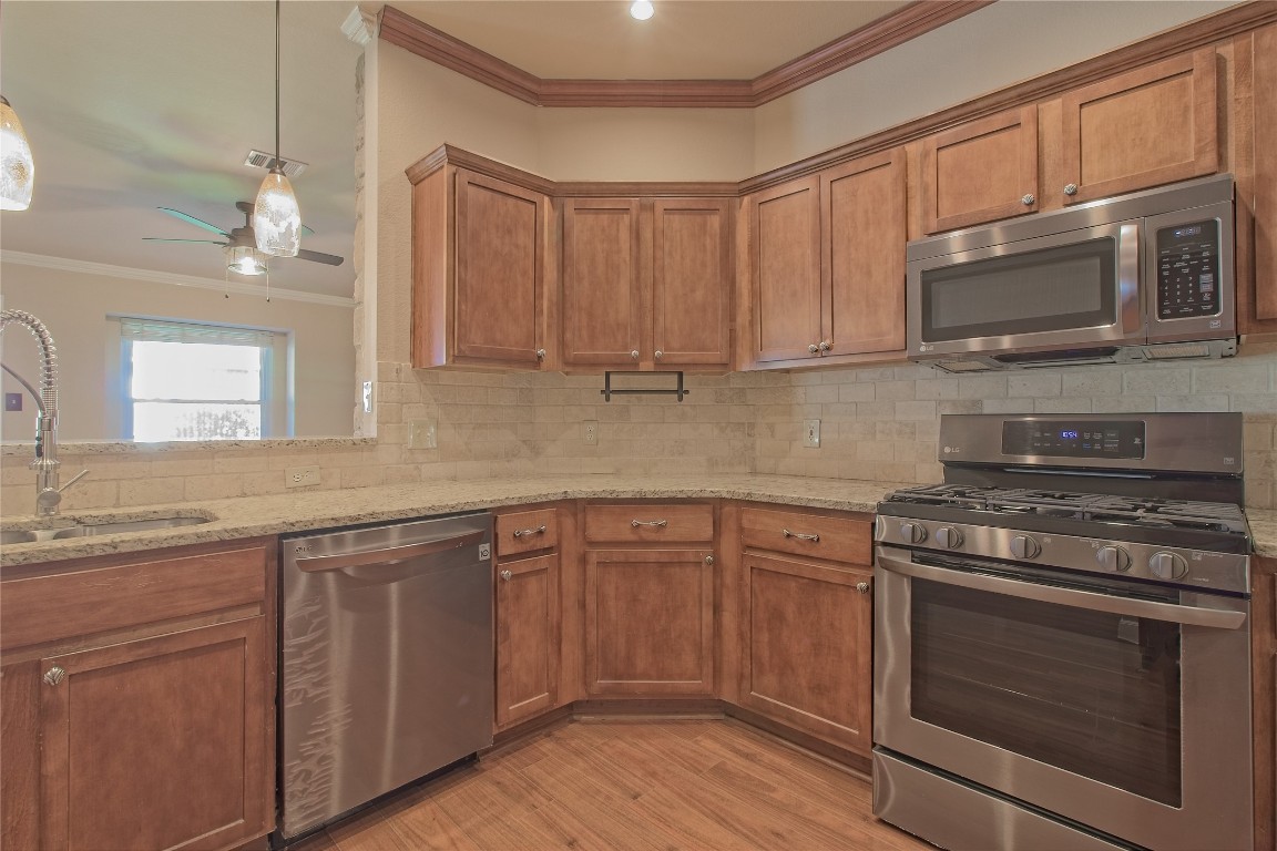 3112 Clinton Place Round Rock, TX 78665 - Photo 13 of 36 a kitchen with stainless steel appliances granite countertop a stove microwave and cabinets