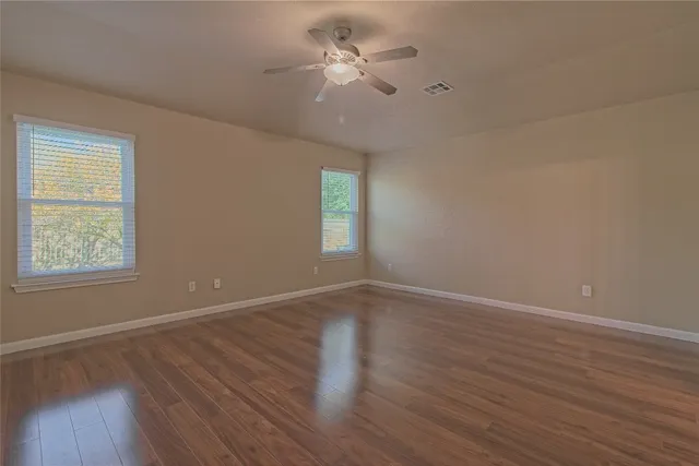 wooden floor in an empty room with a window