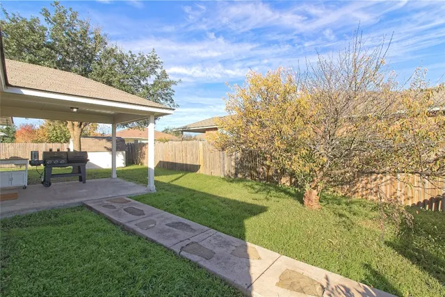 a view of a backyard with couches under an umbrella