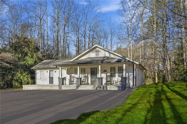 a front view of a house with yard and green space