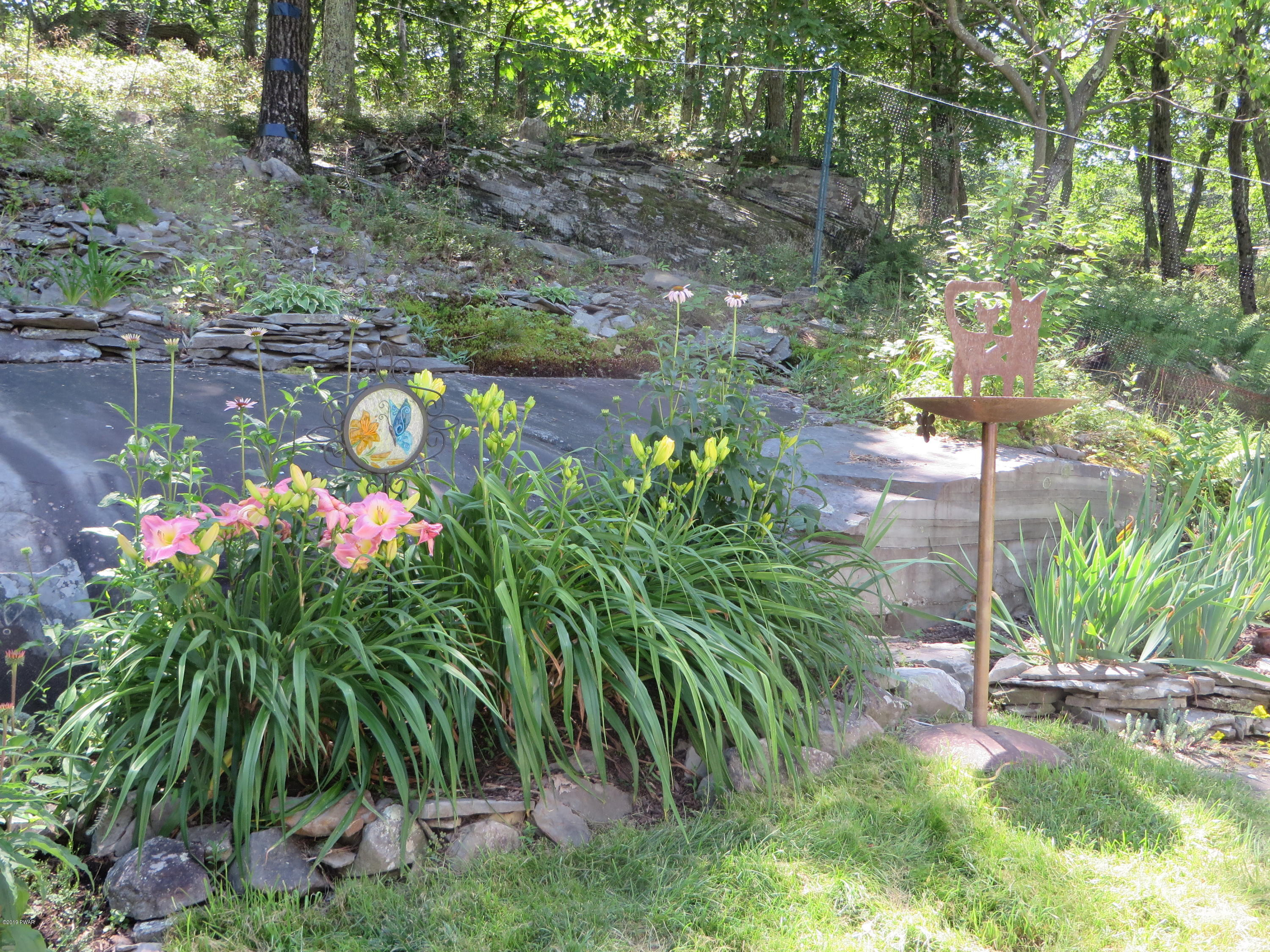 137 Maple Ridge Road Milford, PA 18337 - Photo 29 of 82 a backyard of a house with lots of green space and a fountain