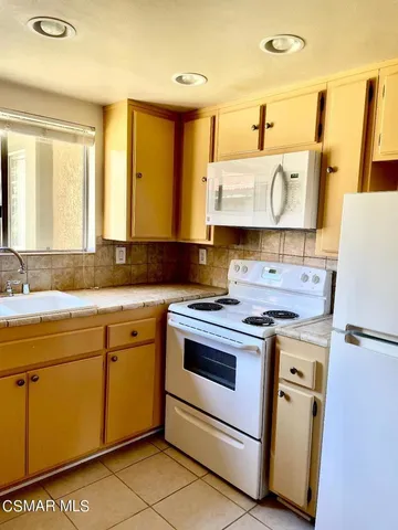 a kitchen with a stove a sink and a refrigerator